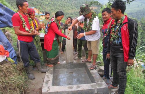 A group of Nepal people in a remote community demonstrate the working of a new tap