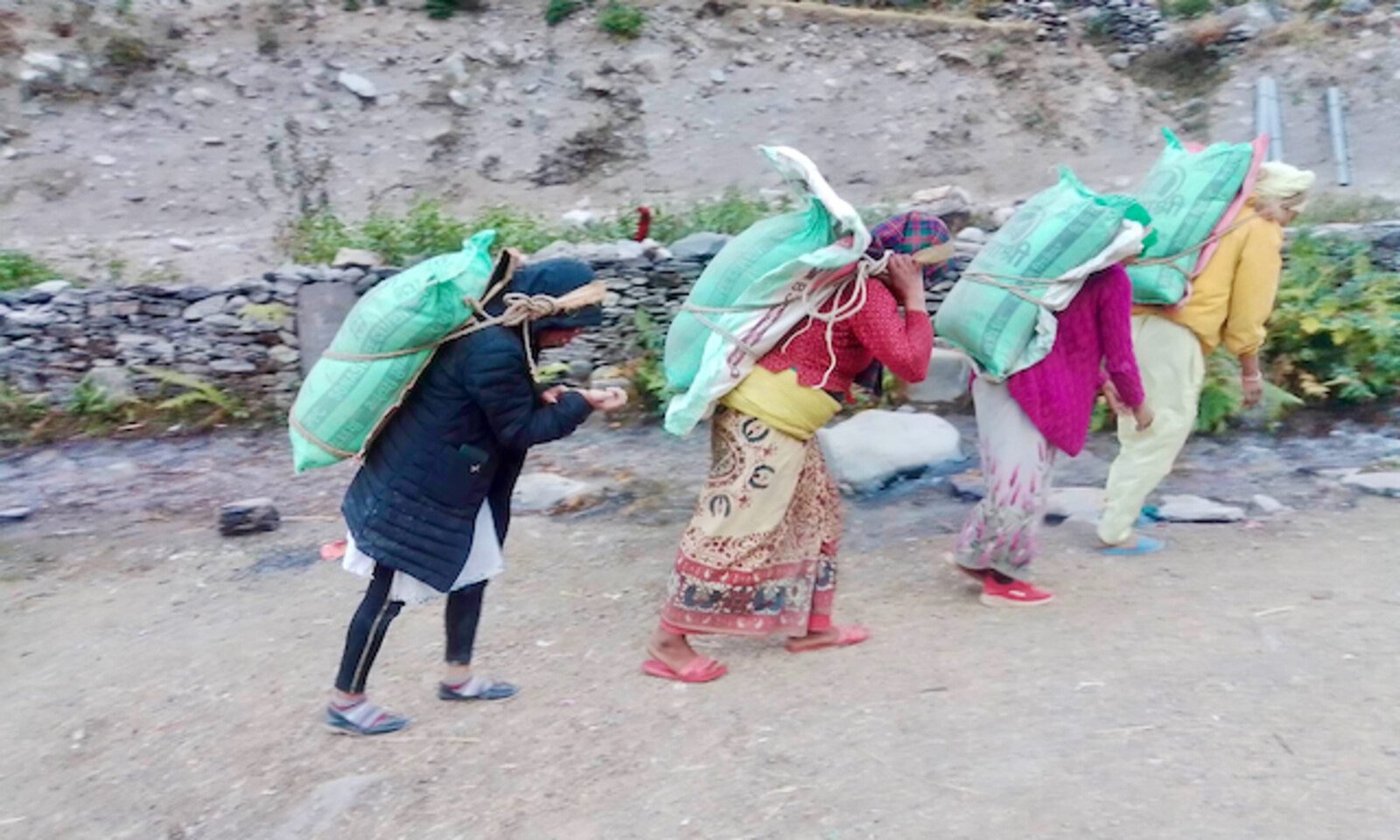 Nepali women carry 50kg bags of cement to help build a Birth Centre in the remote community of Aathbiskot, West Rukum, Nepal